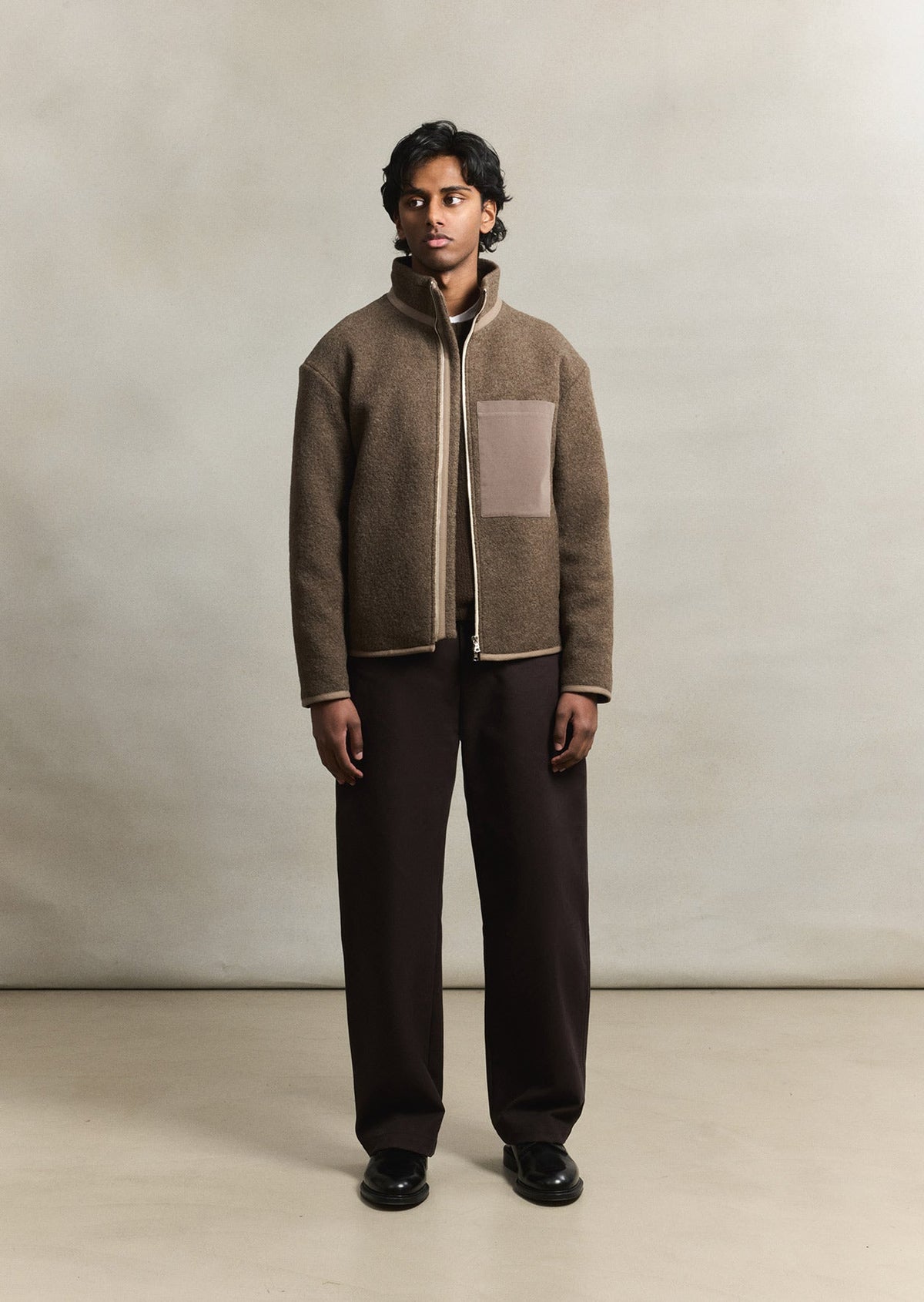 Model wearing the De Bonne Facture Boiled Wool Bookstore Jacket in Ash Brown.