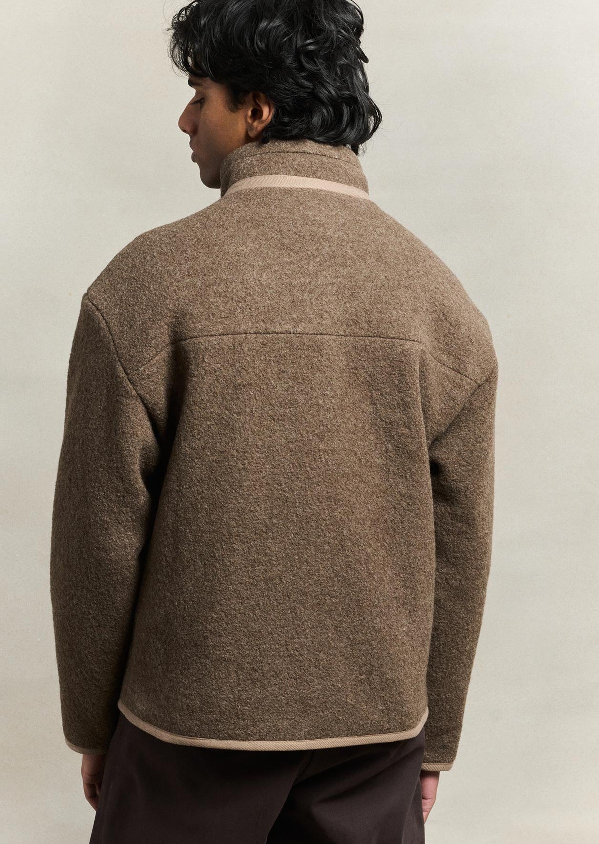 Back view of the model wearing the De Bonne Facture Boiled Wool Bookstore Jacket in Ash Brown.