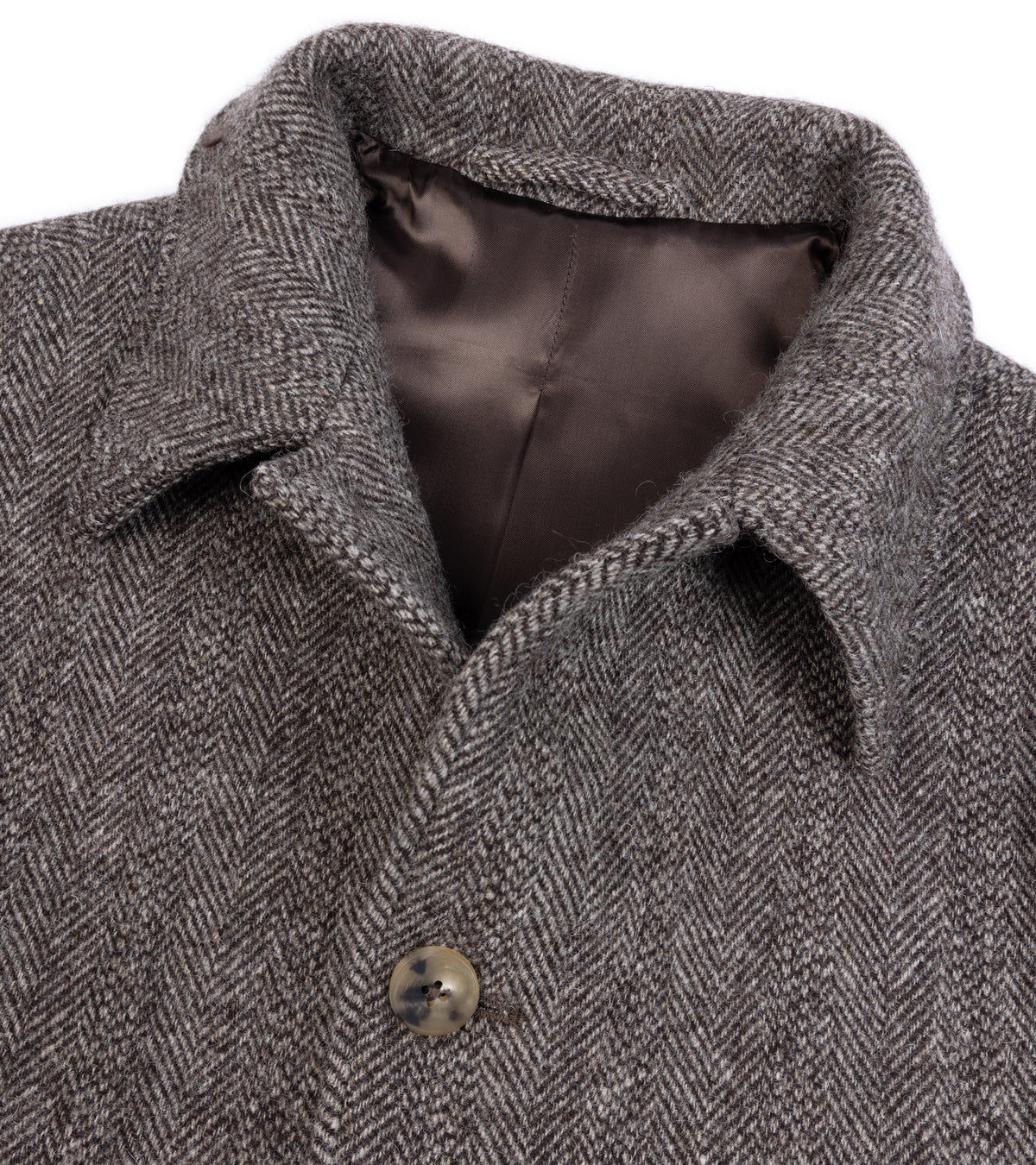Close-up of the De Bonne Facture Herringbone Wool Overcoat in Undyed Brown showing a dark brown satin lining, front button and fabric texture.