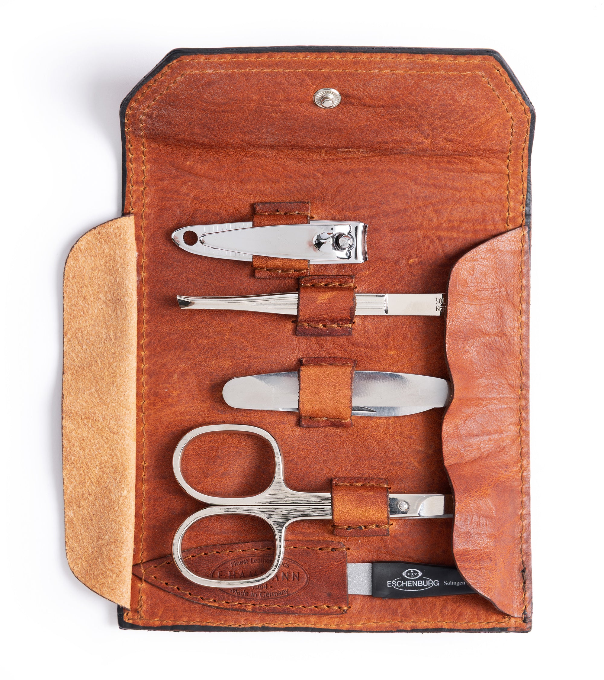 F. Hammann leather grooming set in tan showing the inside detail and five-piece kit containing, nil clippers, tweezers. folding knife, nail scissors and nail file.