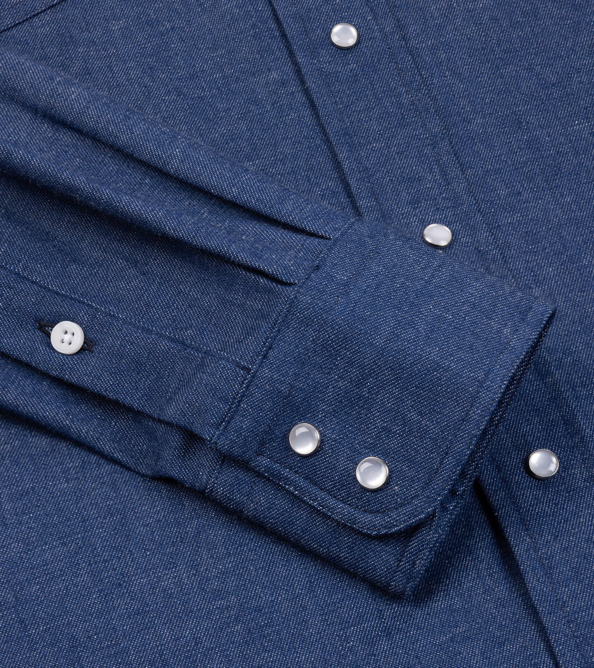 Close-up of the Gitman Vintage Denim Western Shirt in Light Blue showing the cuff with western snap buttons and the fabric texture.