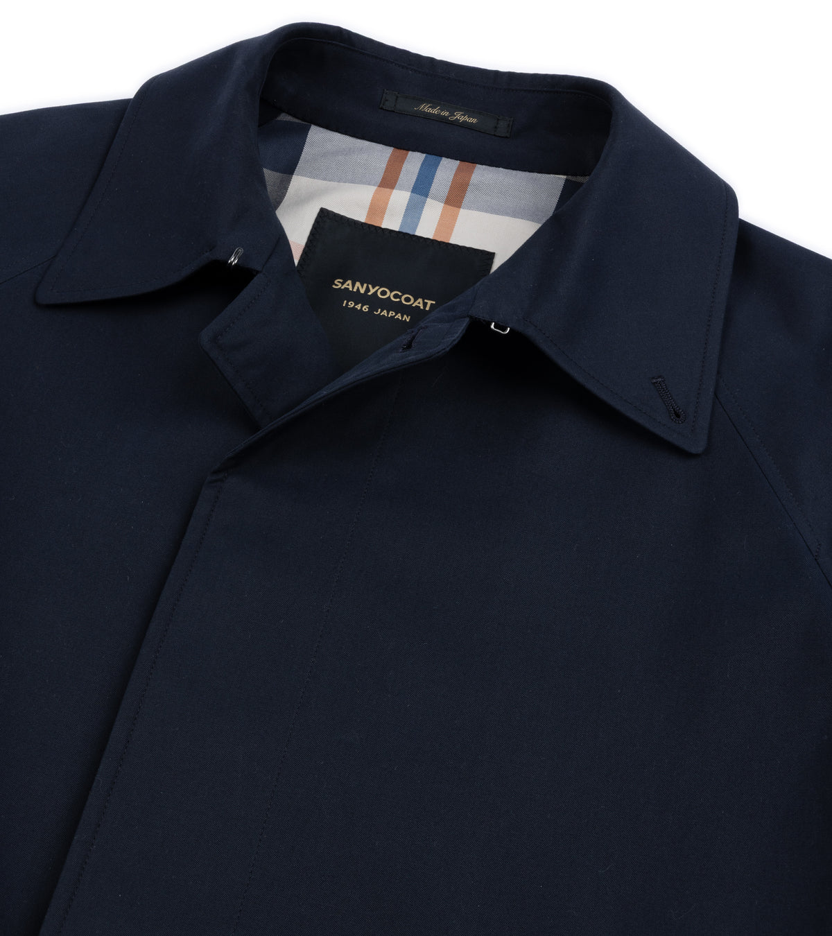 Close-up collar and lining detail of the Sanyo 100 Year Lightweight Gabardine Balmacaan Coat in Navy. Made in Japan label shown on the collar.