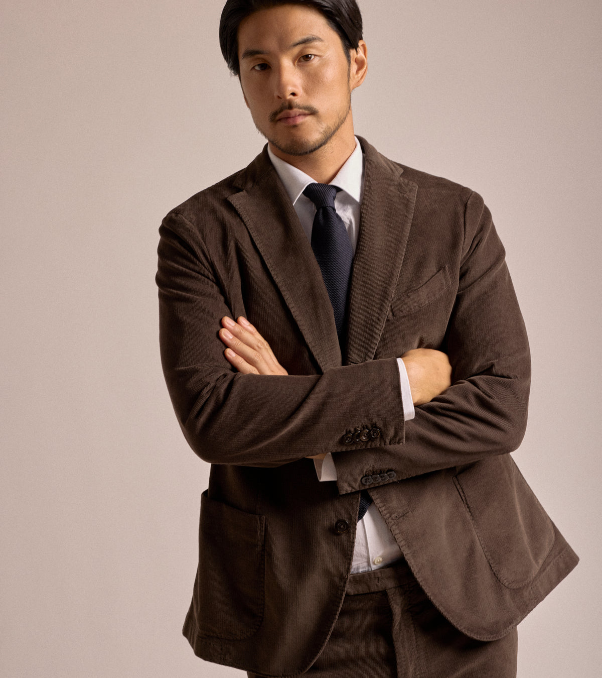 Model wearing the Boglioli Cotton Corduroy Suit Jacket in Brown styled with a white dress shirt and navy tie.