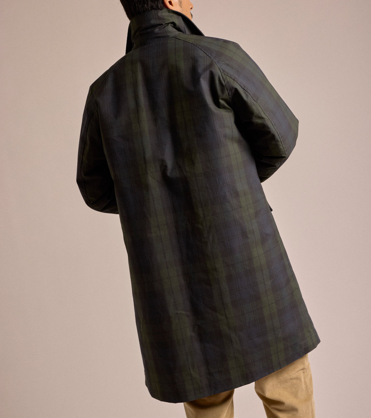 Model wearing the East Harbour Surplus Baxter Waxed Raglan Trench Coat in Blackwatch, shown from the back.