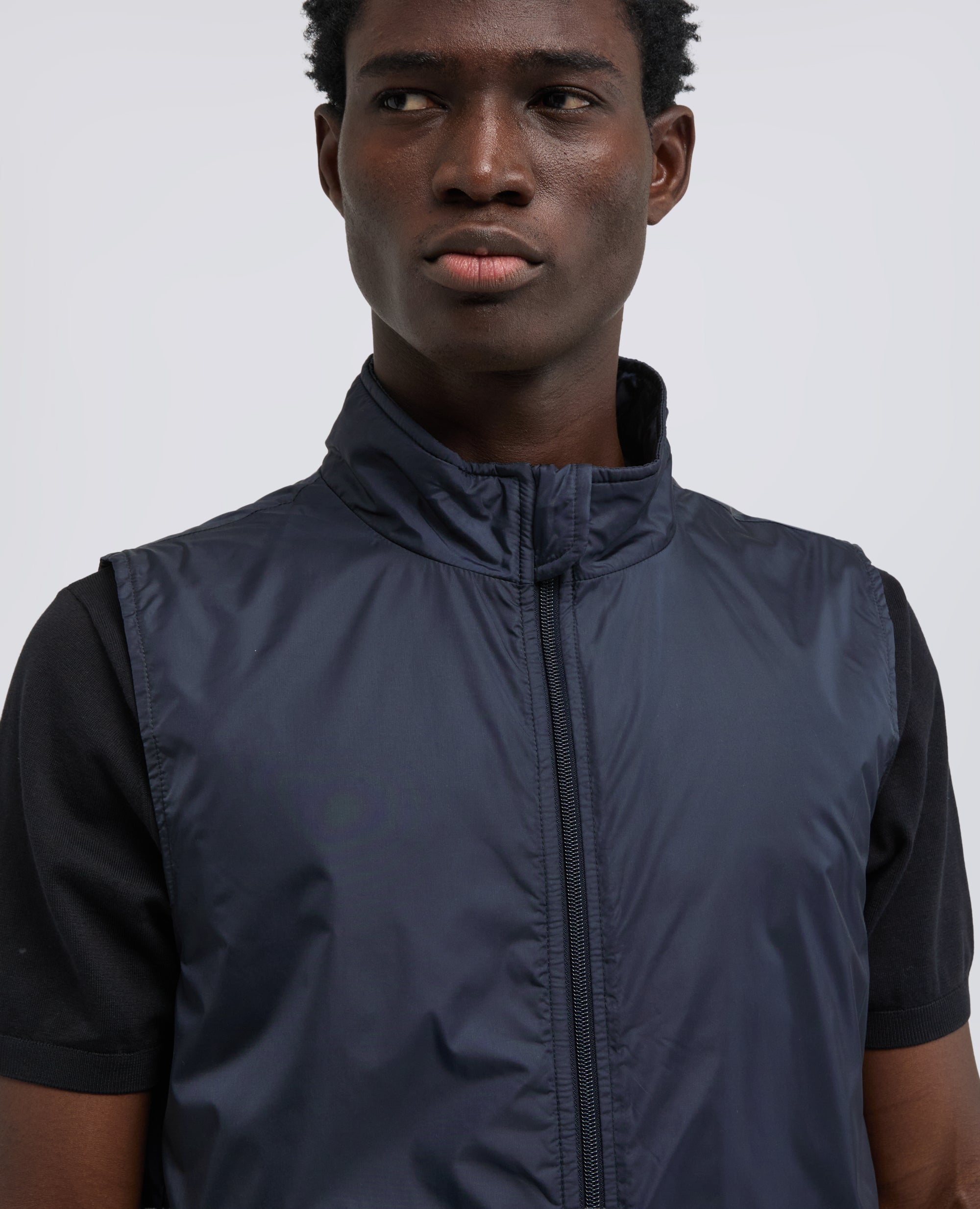 Model wearing Aspesi Vernes gilet in navy nylon, close-up collar and chest.