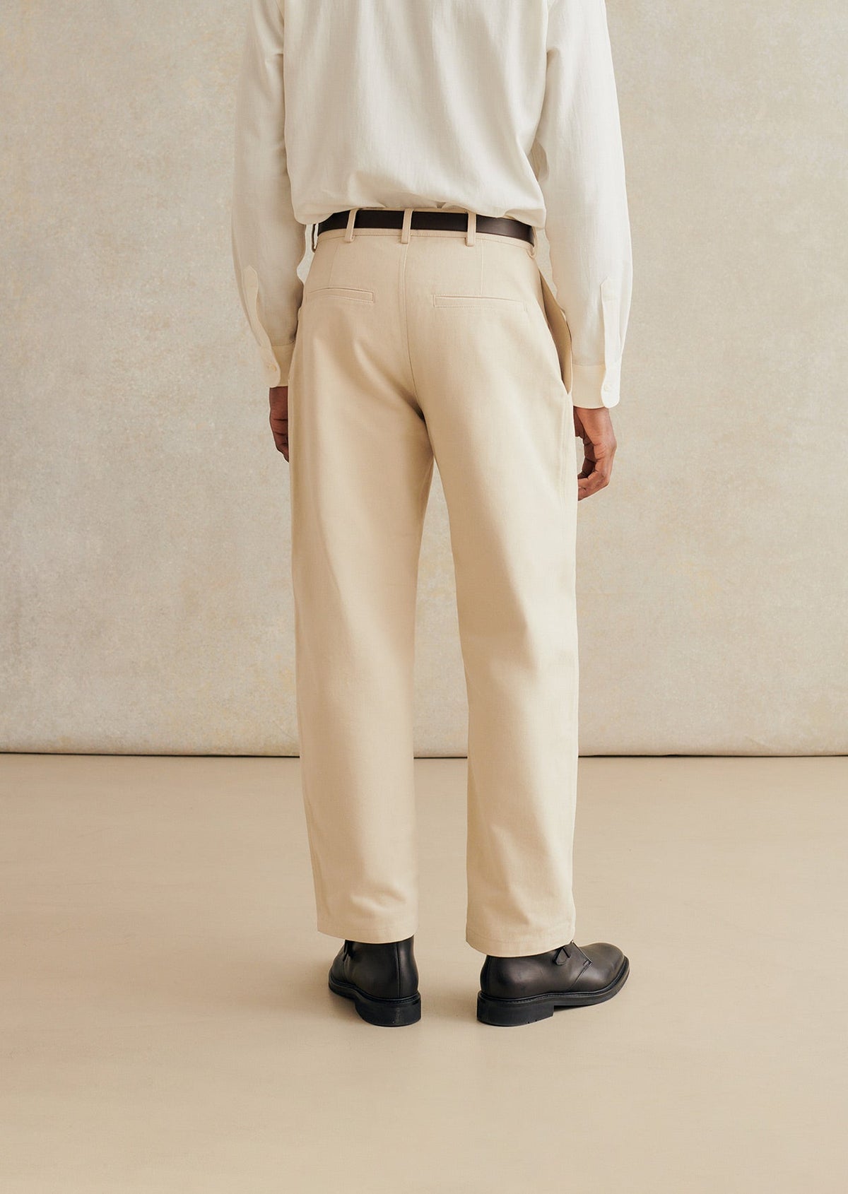 Model shown from the back wearing the De Bonne Facture Heavy Cotton Balloon Trousers in Cream.