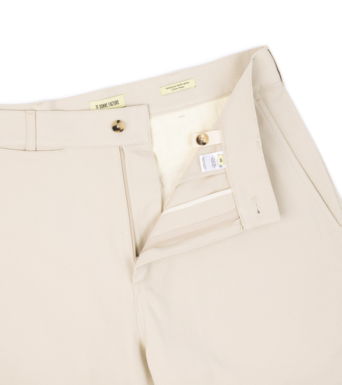 Close-up of the De Bonne Facture Heavy Cotton Balloon Trousers in Cream showing the waistband and button closure.