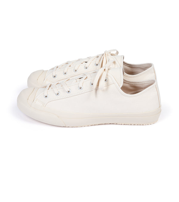 A pair of beige canvas sneakers with lace-up closure, displayed against a white background.