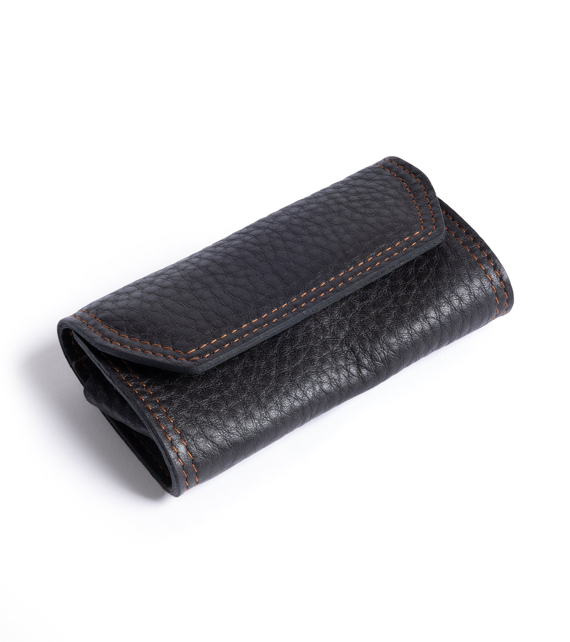 F. Hammann leather grooming set in dark brown, top view from an angle. Detail of the grained leather with contrast light brown stitching.