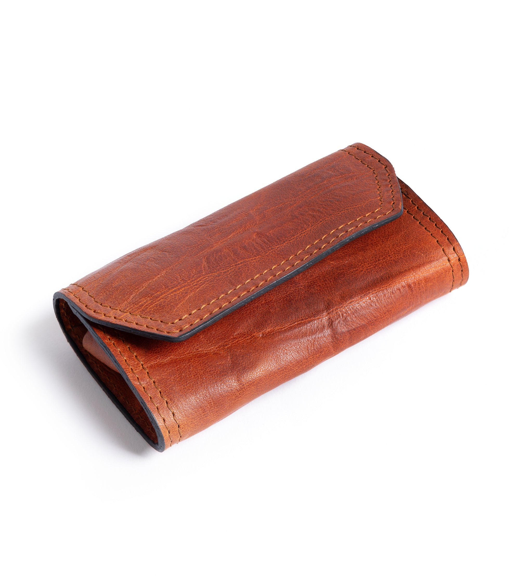 F. Hammann leather grooming set in tan, top view from an angle. Detail of the grained leather with contrast light brown stitching.