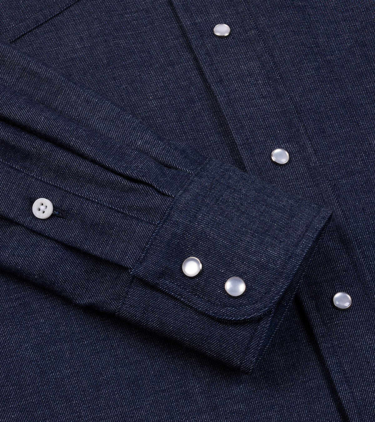 Close-up of the Gitman Vintage Denim Western Shirt in Dark Blue showing the  cuff with western snap buttons and the fabric texture.