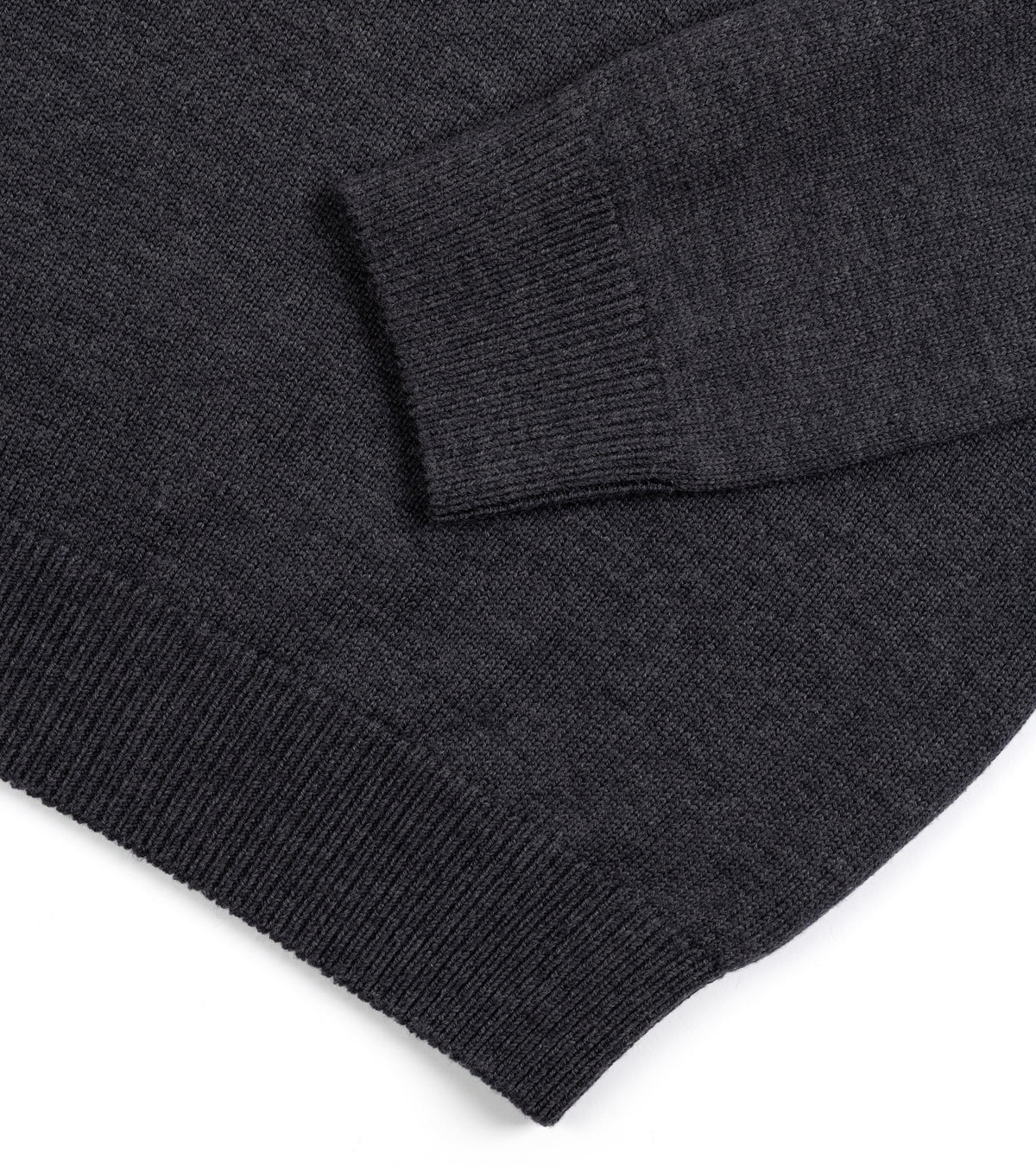 Close-up of the rib cuff on sleeve and hem of the Mooncastle Merino Roll Neck Sweater in Dark Grey.