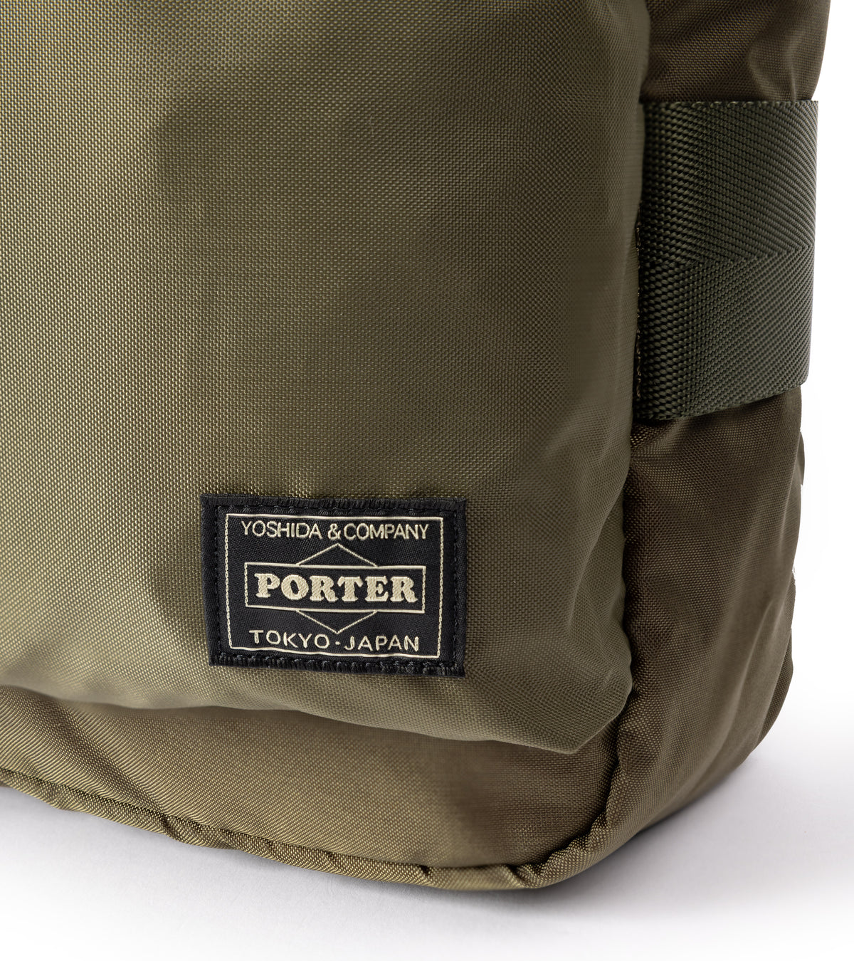 PORTER Force Shoulder Bag in Olive. Close-up detail of the Porter label and fabric.