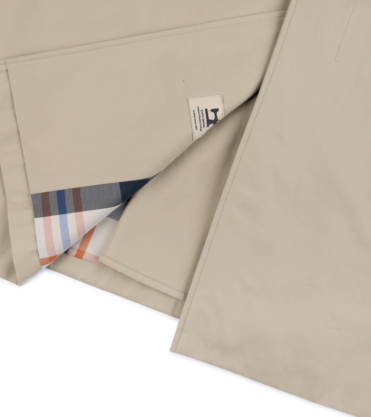 Close-up detail of the back hem of the Sanyo 100 Year Lightweight Gabardine Balmacaan Coat in Beige.