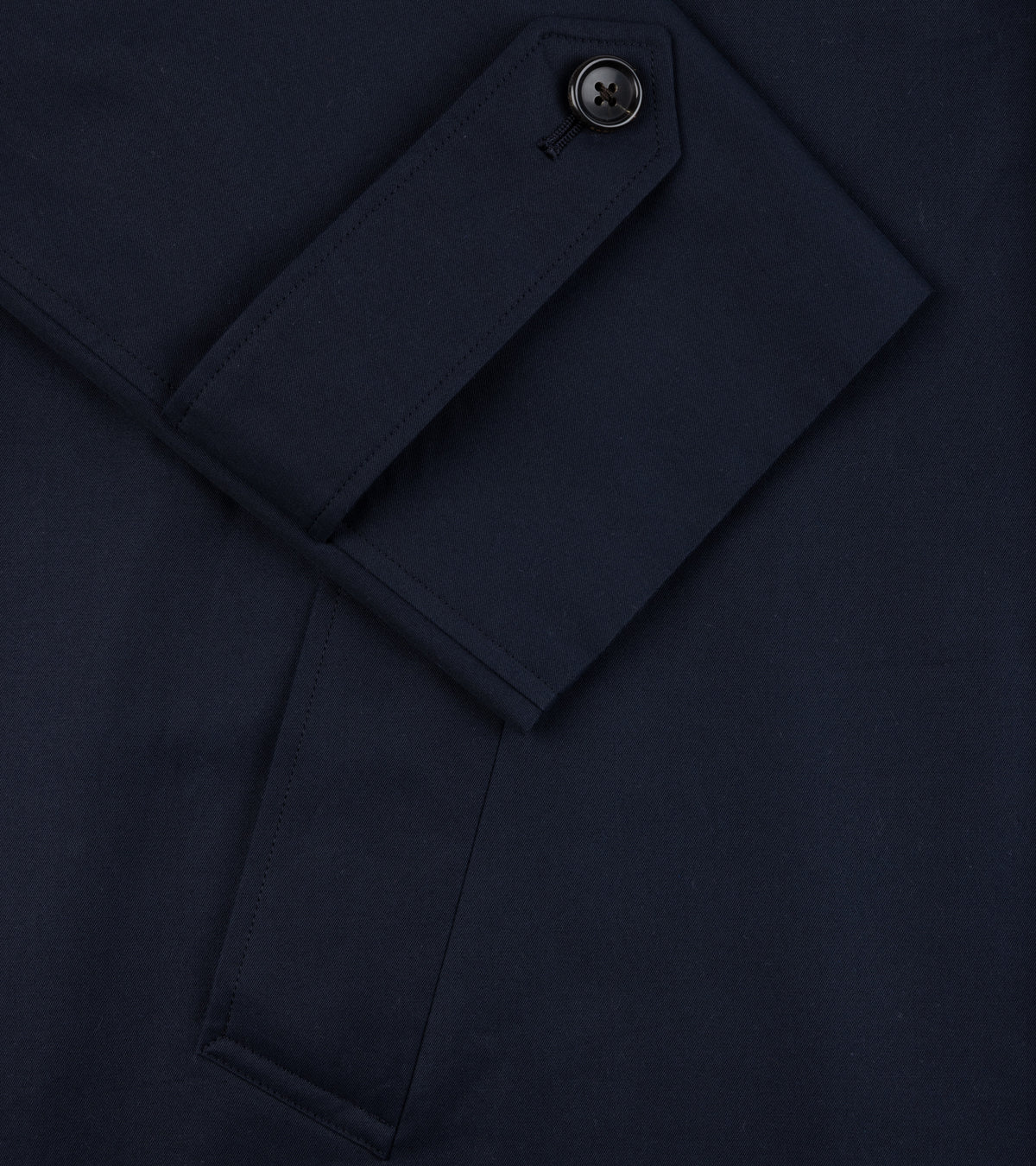 Close-up of the adjustable cuff on the sleeve and pocket detail of the Sanyo 100 Year Lightweight Gabardine Balmacaan Coat in Navy.