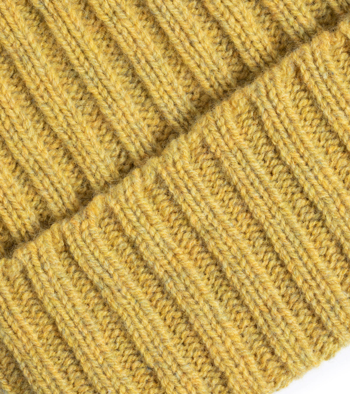 Close-up of the Trunk Lambswool Ribbed Beanie in Citrus showing the fabric texture, the detailed weave and folded pattern.