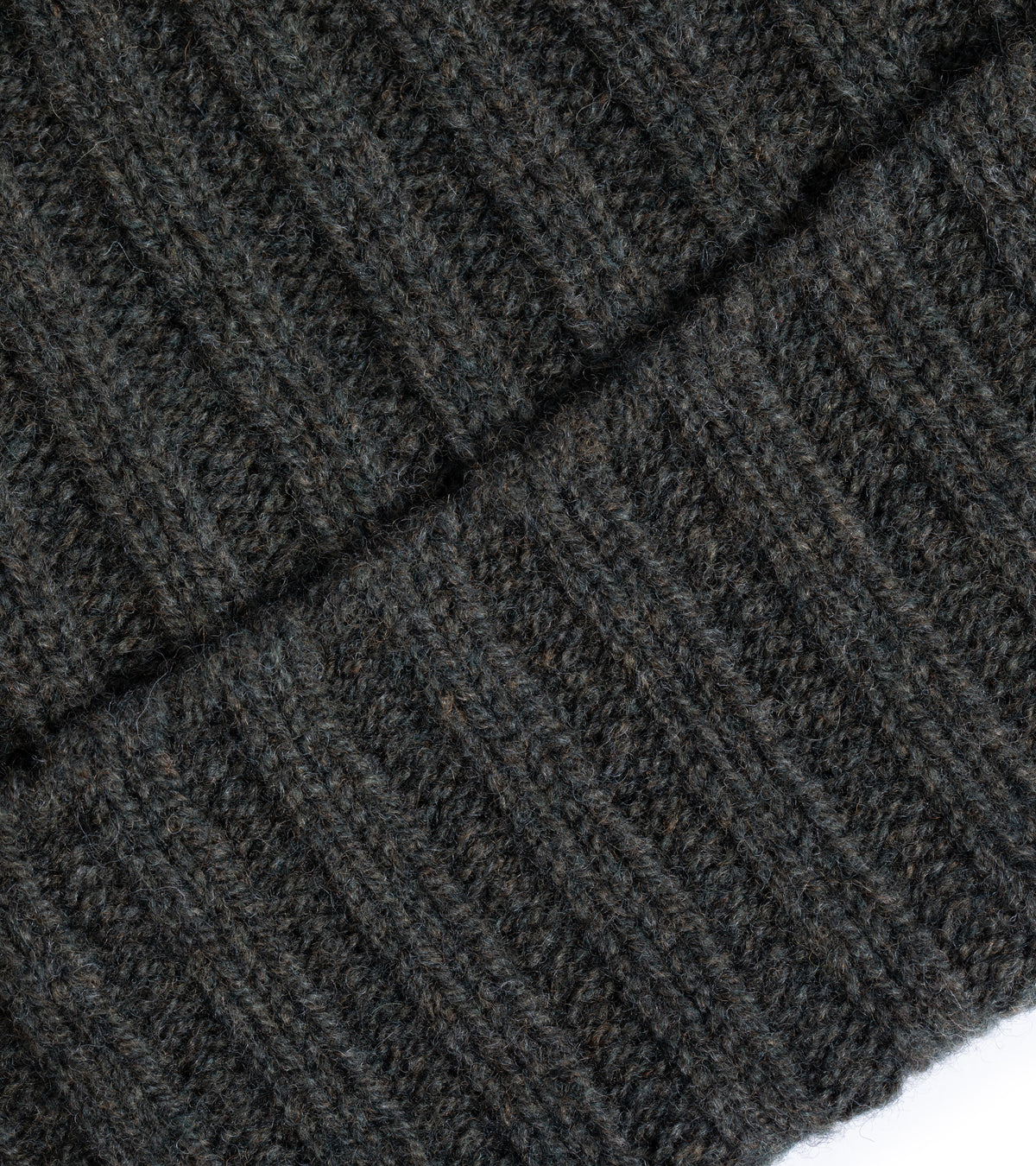 Close-up of the Trunk Lambswool Ribbed Beanie in Olive showing the fabric texture, the detailed weave and folded pattern.