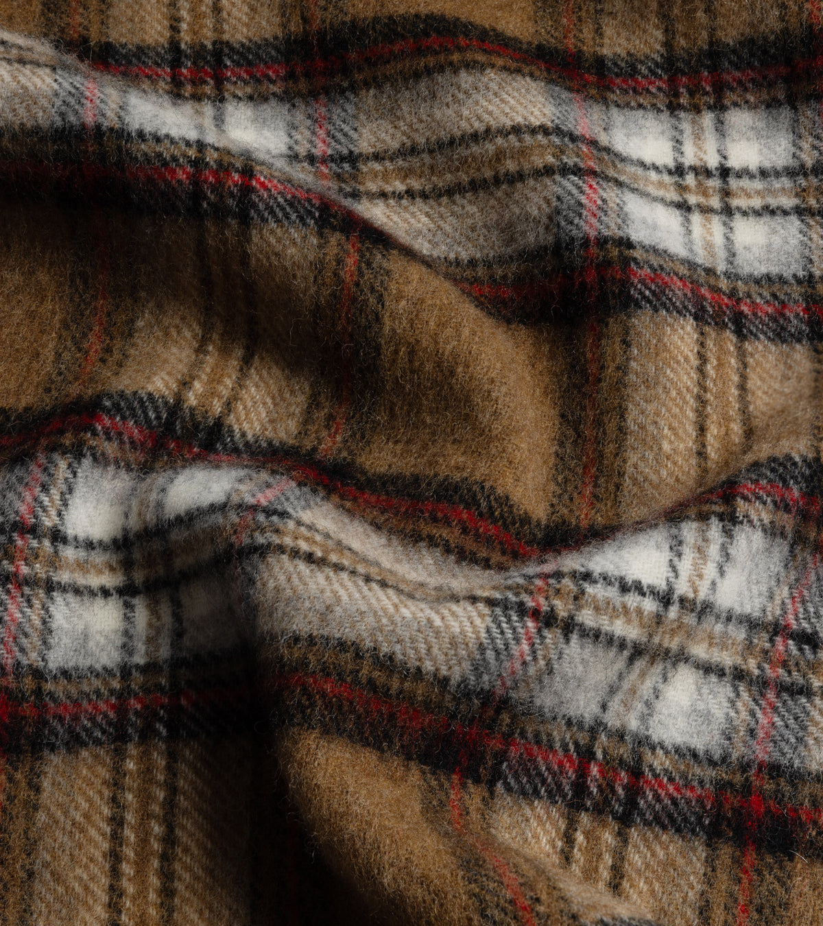 A close-up of the Trunk Moon Merino Check Scarf in Camel/Red showing the fabric texture and check design.