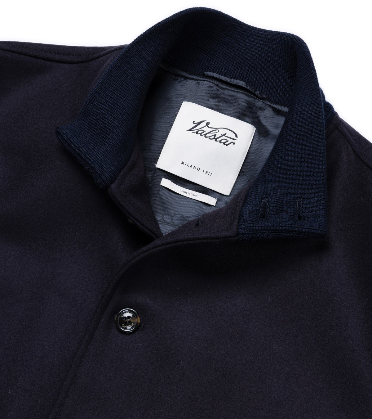 Valstar Valstarino Wool Felt Jacket in Navy. Close-up detail of the collar spread with the top button undone. Valstar label shown and Valstar branding on the button.