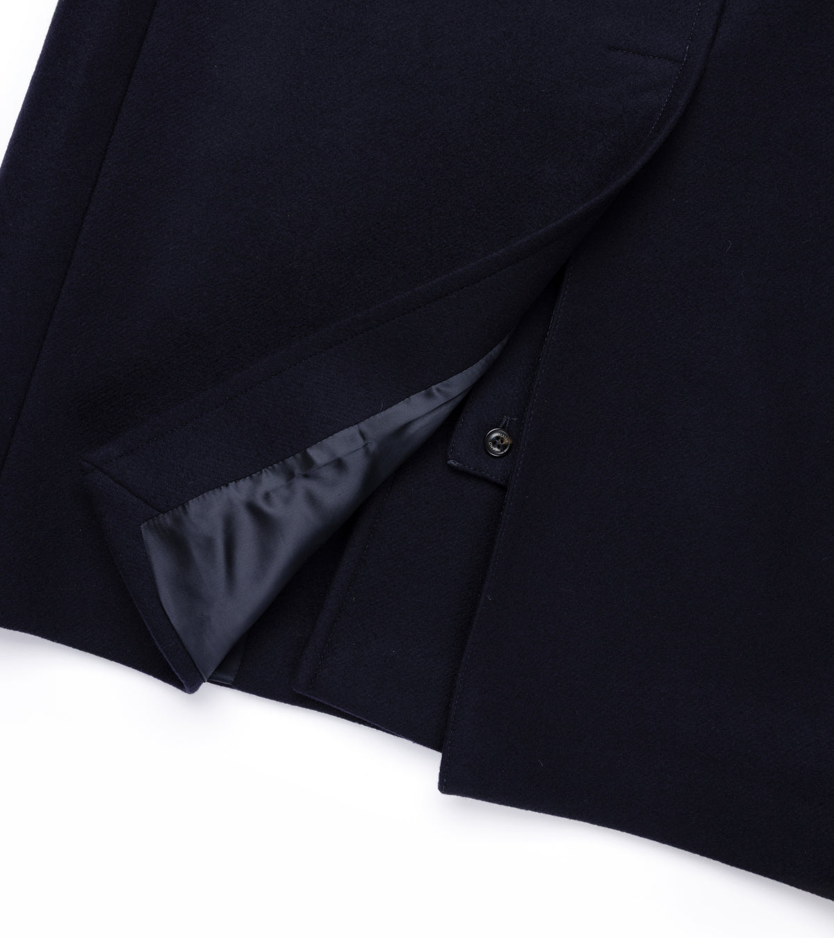 Valstar Vittorio Wool Felt Raglan Overcoat in Navy. Close-up detail of the back hem showing the vent opening with navy viscose lining and a button tab.